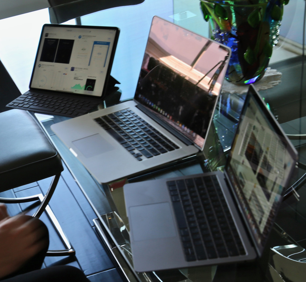 A 12.9-inch iPad Pro next to a 15-inch MacBook Pro and 13-inch MacBook Air.