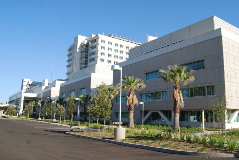 Exterior of teaching hospital with palm trees.